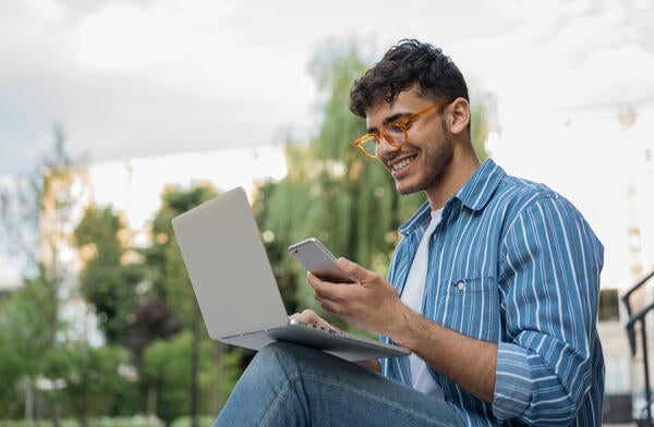 Man using computer and phone to place a call